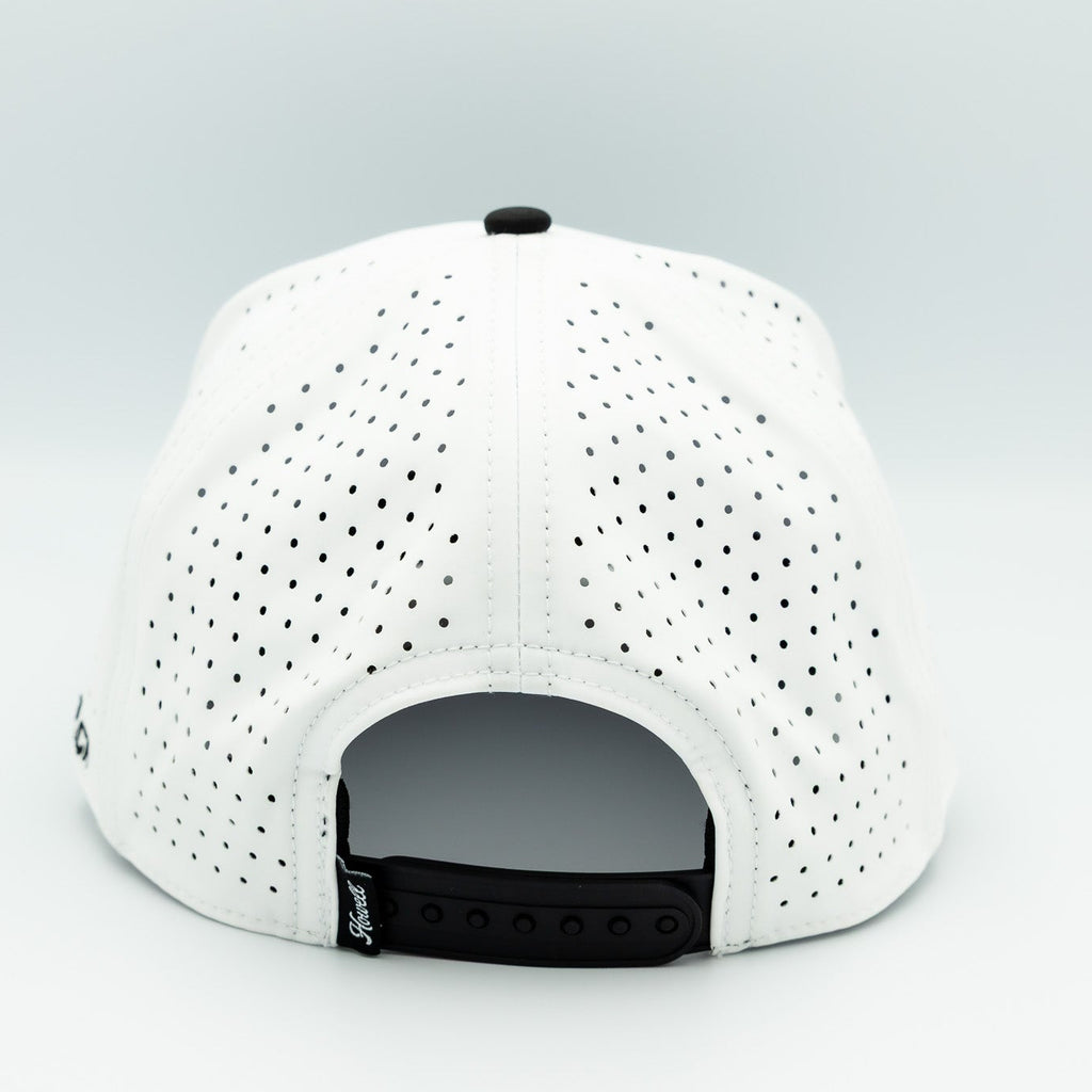 White baseball cap with black perforations on a light gray background