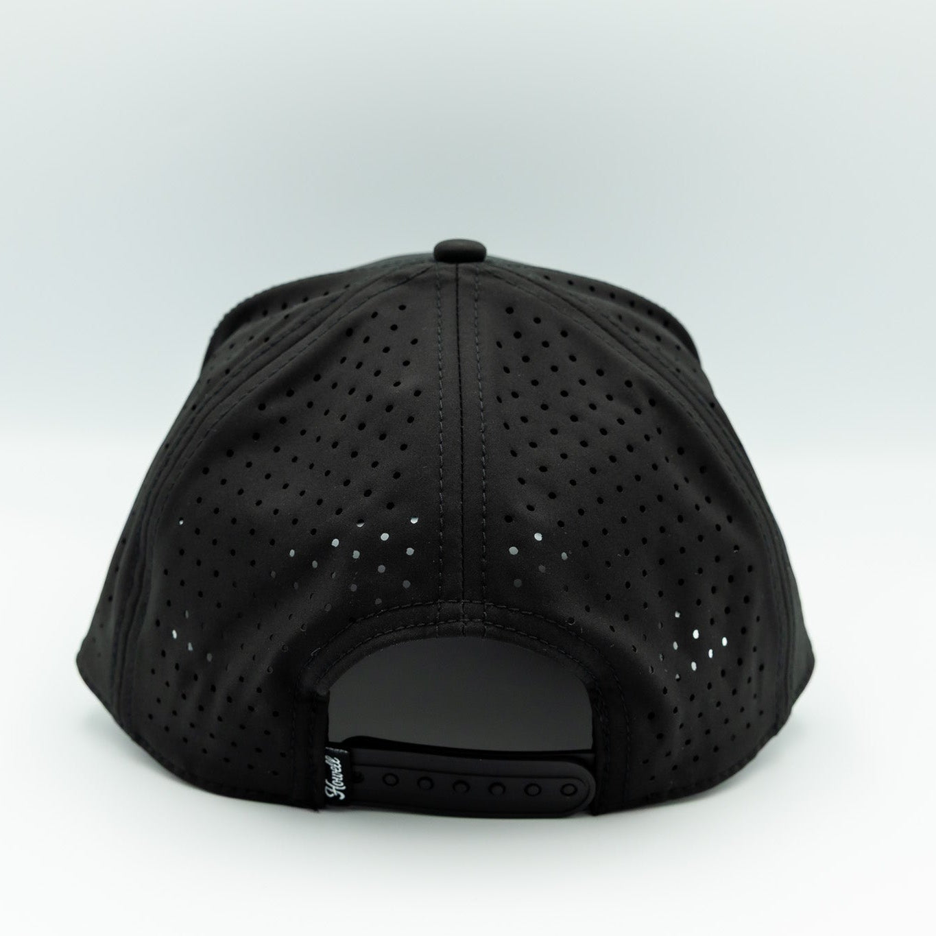 Black cap with perforated design on a white background