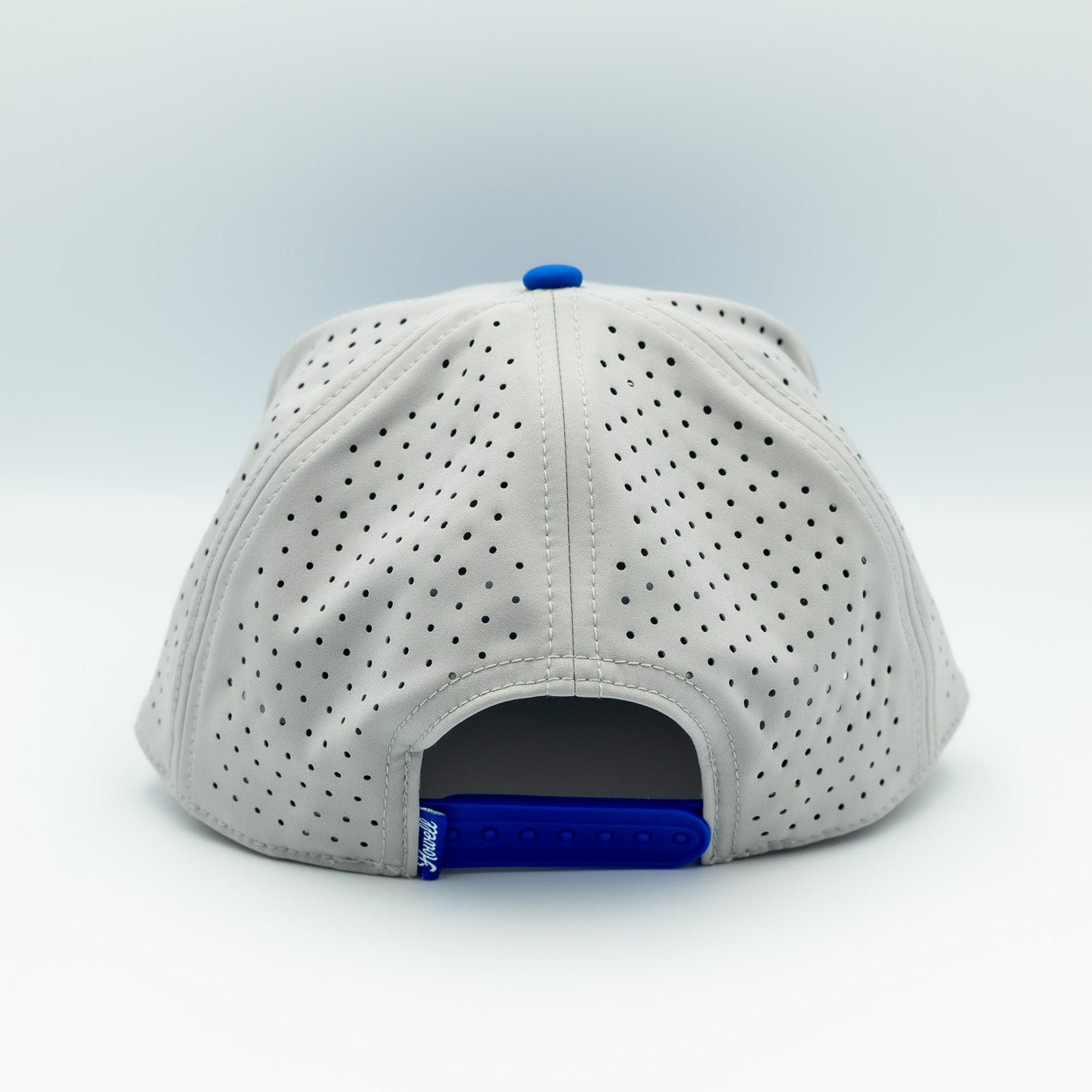 White baseball cap with blue interior on a light gray background