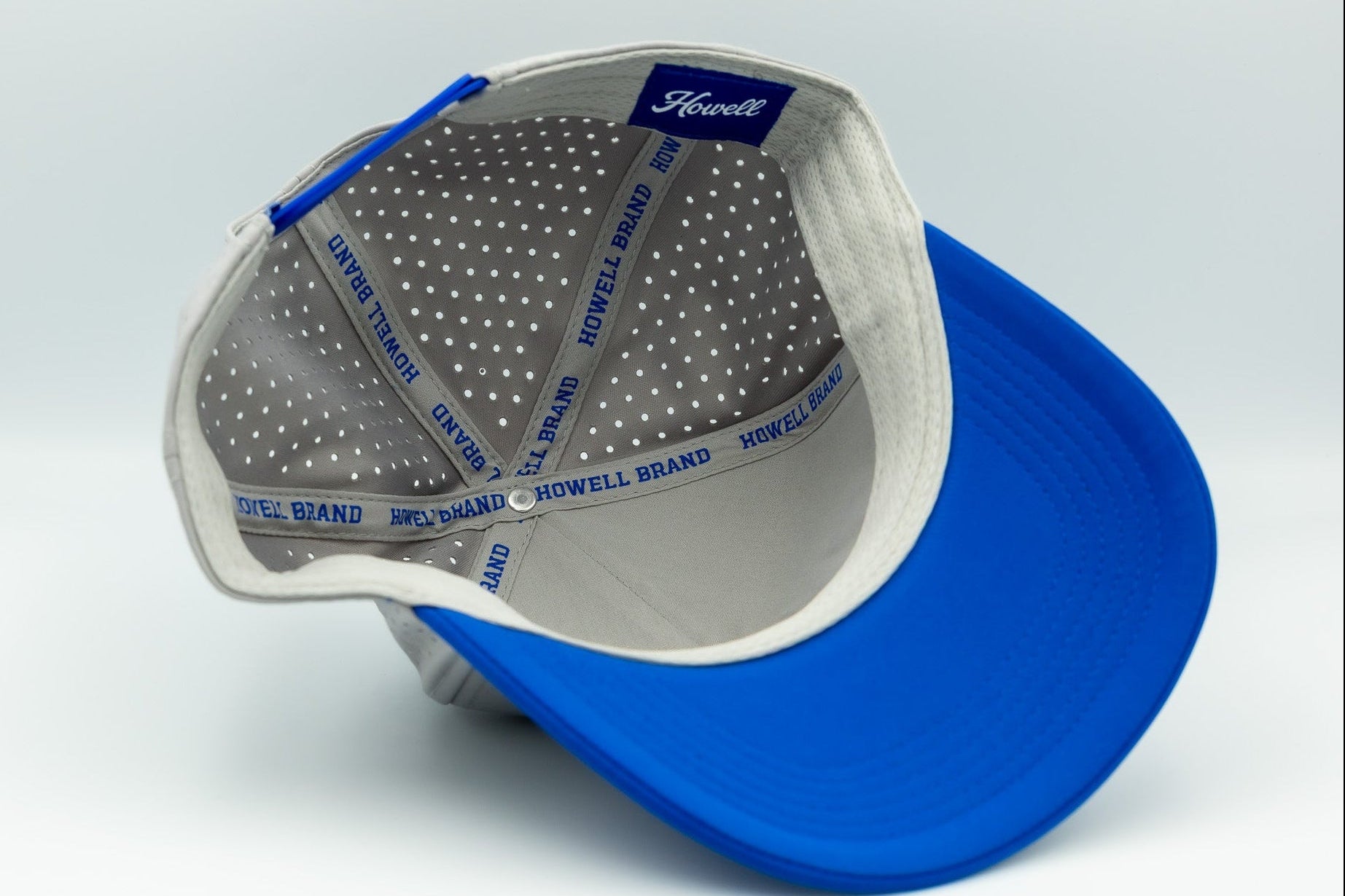 Blue cap with white interior and visible branding on a light gray background