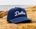 Blue cap with 'Dallas' text on a rocky surface